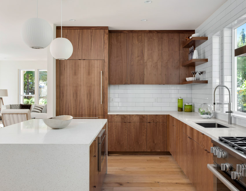 Floors and cabinets made of wood, quartz waterfall countertop, center island and hanging light