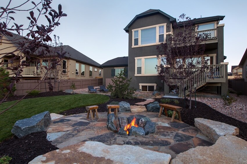 Fully landscaped backyard with a beautiful fire pit and stone patio