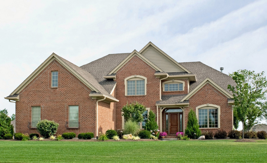 House constructed of red bricks glass windows landscaped front area