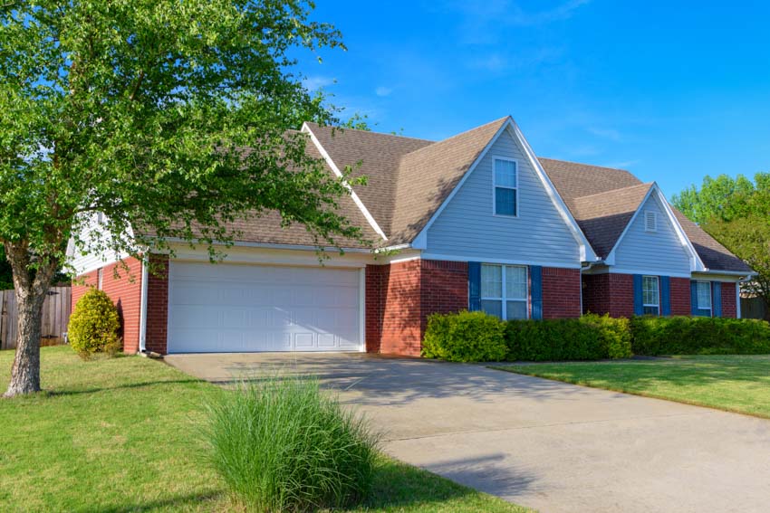 House exterior with brick, and pitched roof garage 