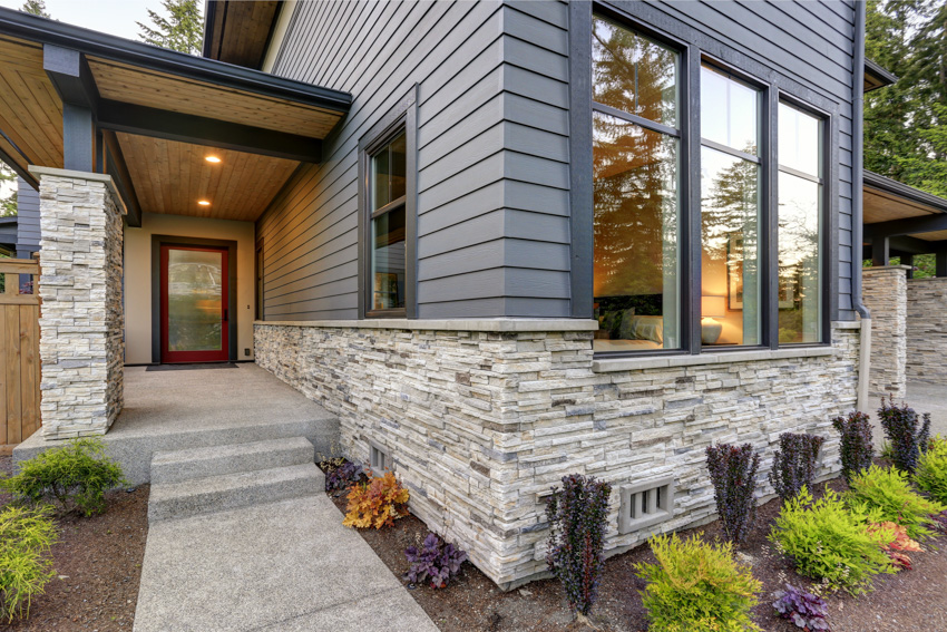 House with wood and stone siding walkway glass front door