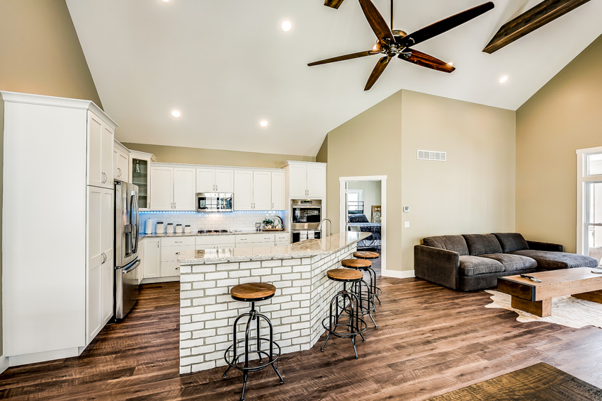 Kitchen with faux brick counters with marble tops, beige walls and ceiling fan