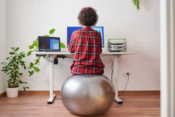 Lady Sitting On Exercise Ball Home Office Wood Flooring Indoor Plant Is 608x406 