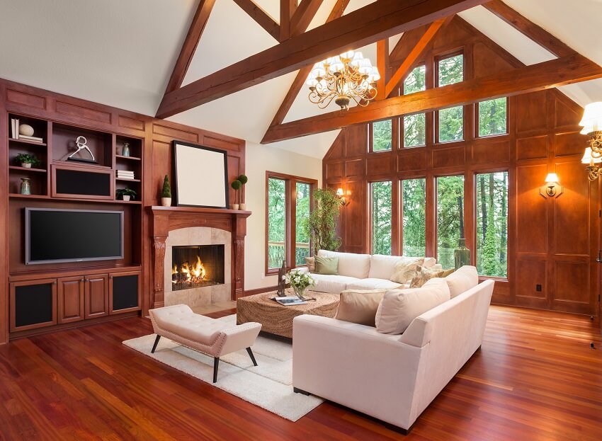 Living room interior with hardwood floors and fireplace in new luxury home with built ins with television and vaulted ceilings