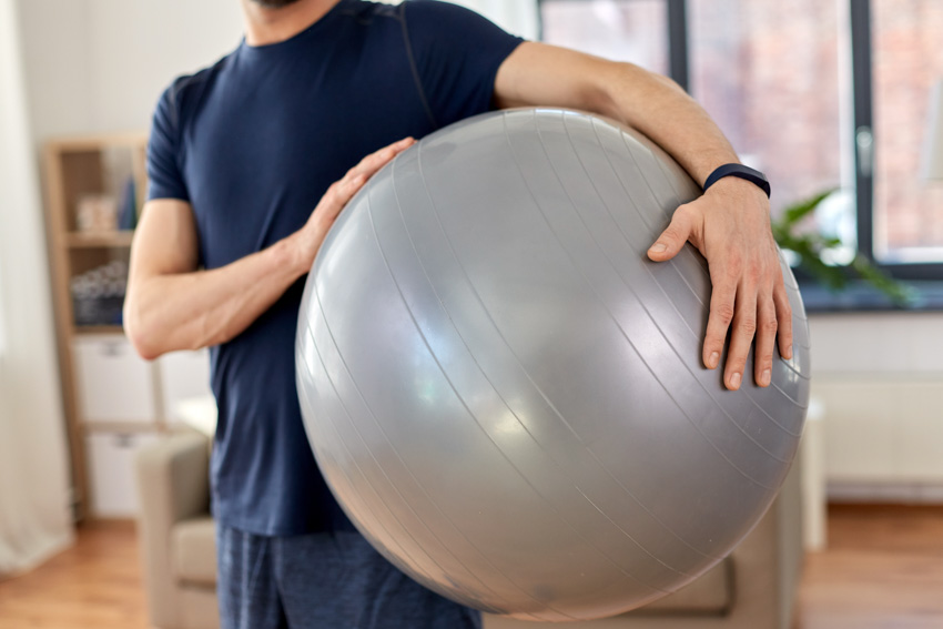 Man carrying silver exercise ball