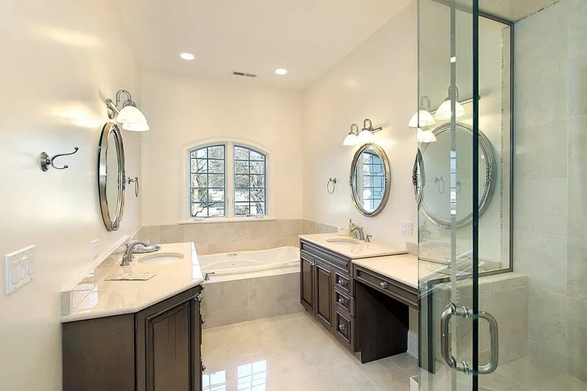 Master bathroom with glass shower mirrors bathtub and dark cabinets