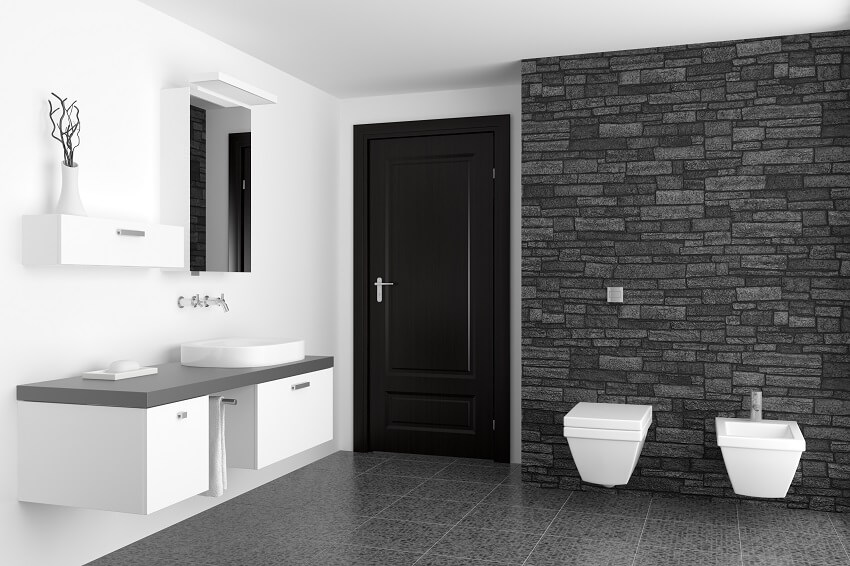 Bathroom with black faux stone cladding wall and white toilet 