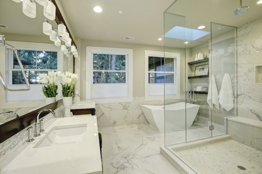 Modern bathroom with marble like porcelain tiles glass shower mirror sink windows lighting