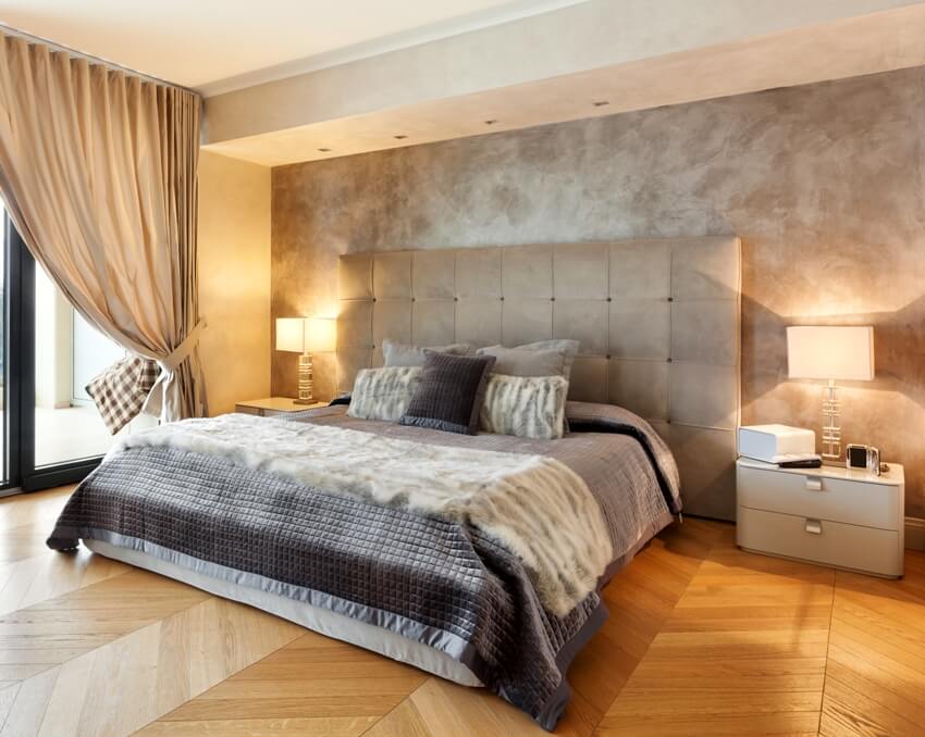 Bedroom with comfortable bed curtains and bedside lamp on table