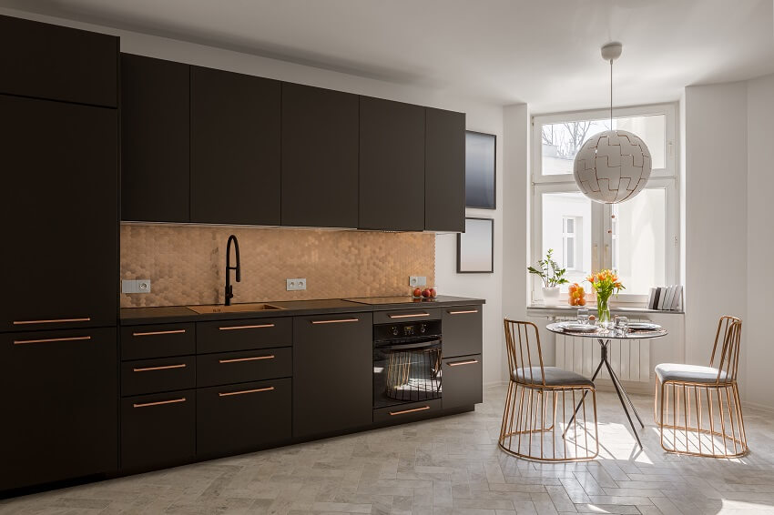 Modern black kitchen with stylish copper details with new dining table and two elegant copper chairs