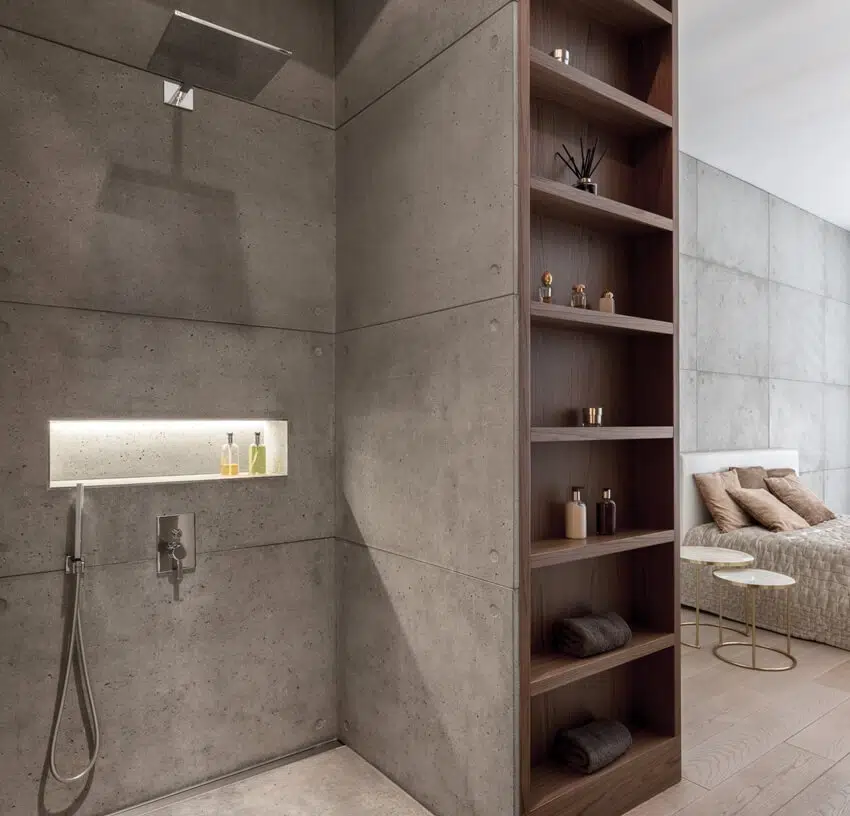 Modern designed bathroom with shower open to bedroom with concrete stucco wall tiles and wooden shelves in the middle