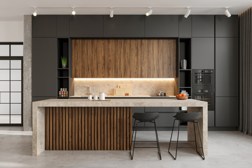 Modern stylish kitchen with black cabinets and waterfall counter island