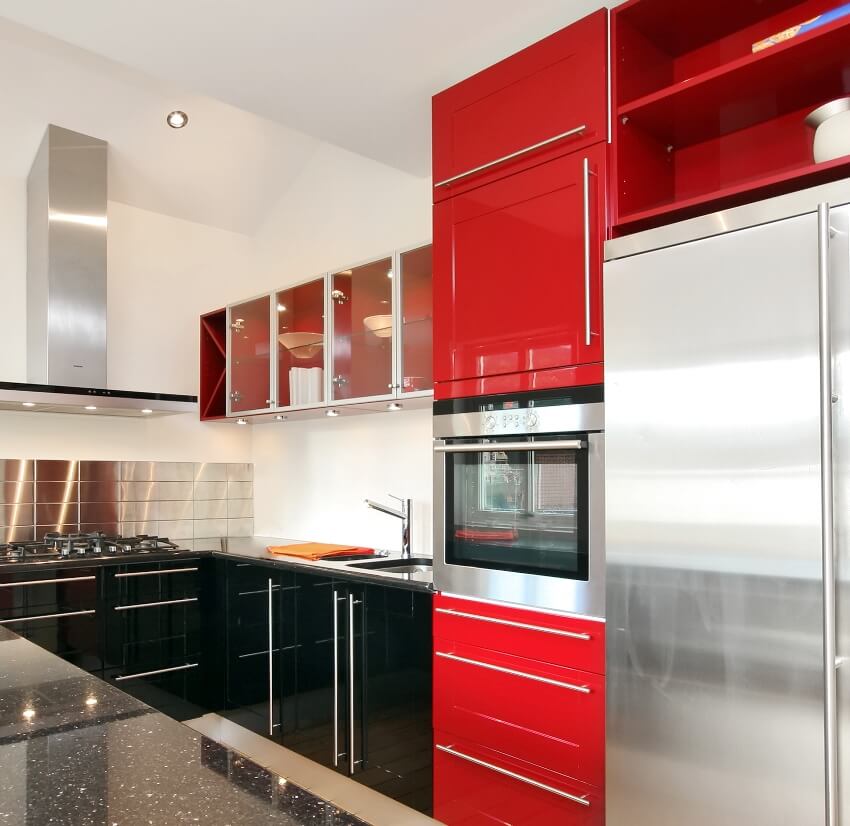 Modern style kitchen with black granite countertop steel fridge and black and red cabinets 