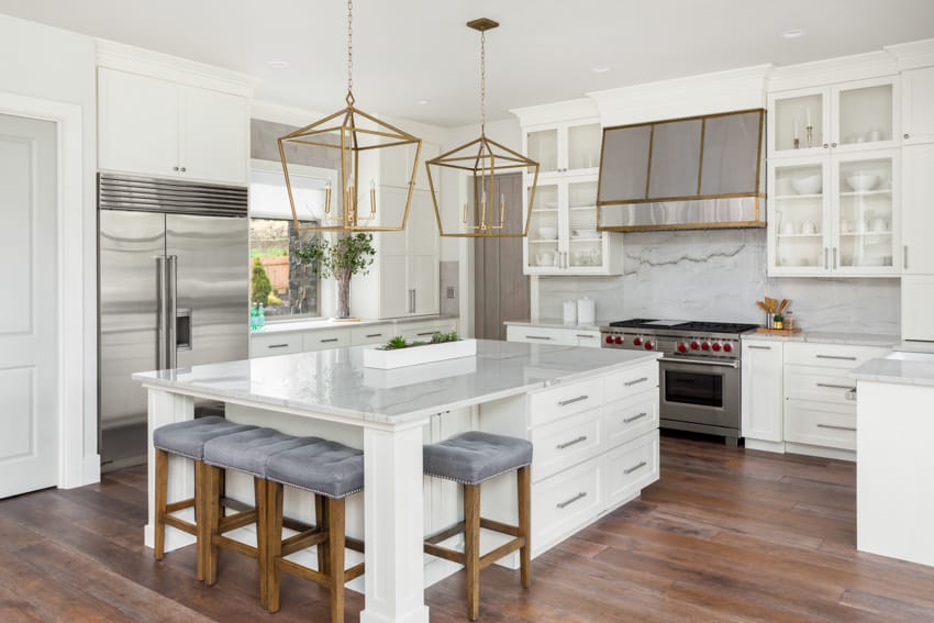 Modern kitchen with hanging lights white cabinets countertop oven hood quartz backsplash wood flooring white walls
