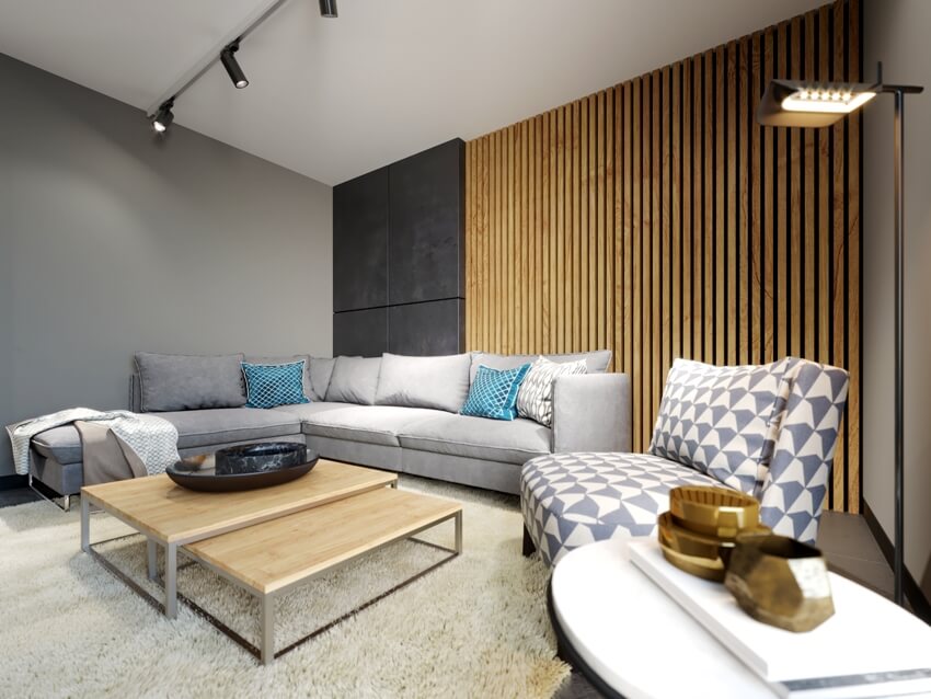 Modern loft interior of living room grey sofa and colorful pillows and dark concrete wall and wood slats accent