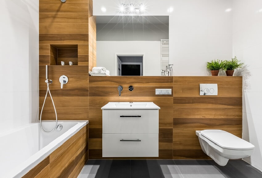 Modern wooden bathroom with PVC panels, bathtub, mirror, toilet, cabinet and sink