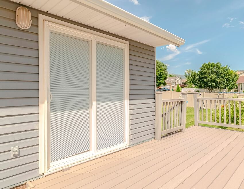 Panorama modern outdoor home deck area with a covered glass doos on sunny day 