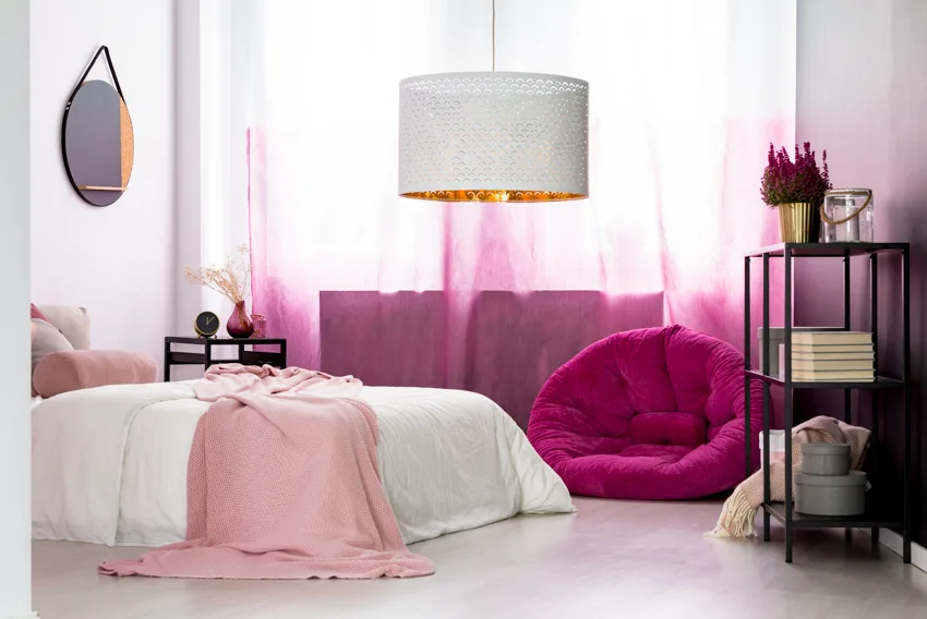 Pink themed room with mirror above bed
