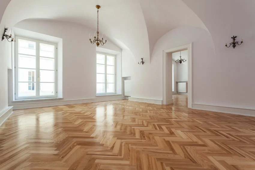 Empty room with herringbone pattern, glass panel windows and white walls