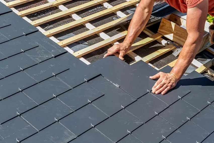 A professional roof worker installing slate roof