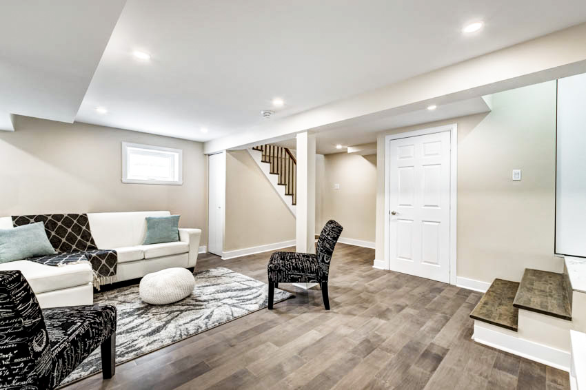 Basement with wooden floor, sofa chairs and ceiling lights