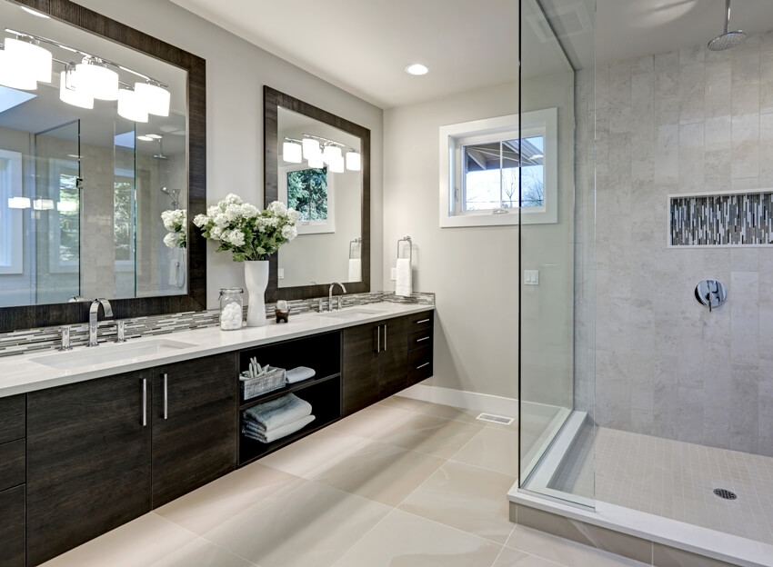 Spacious bathroom in gray tones with heated floors walk in shower double sink vanity and skylights