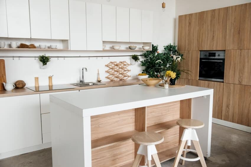 Stylish kitchen in white and brown wood minimalist design with sink table top plants pot shelf for dishes bar stools and table