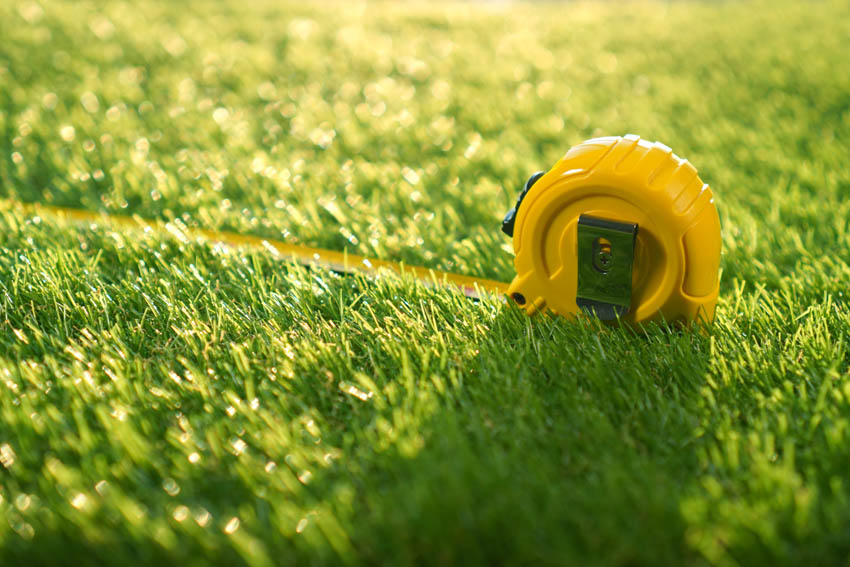 Tape measure on top of yard grass