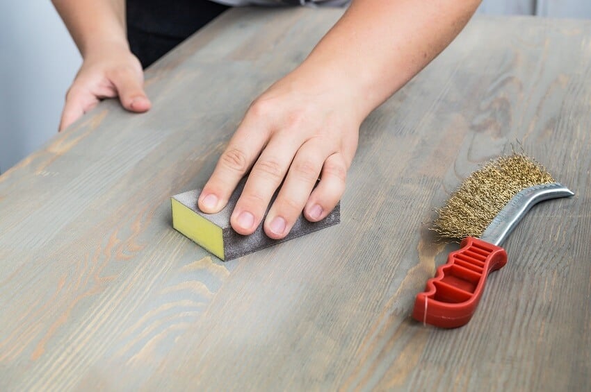 Using sand cloth for finishing distressed pine wood table top