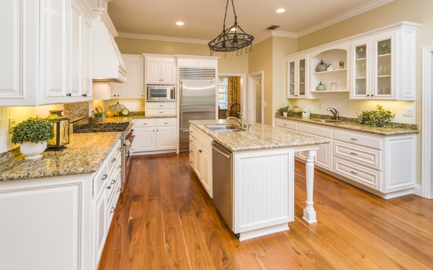 White and wood kitchen with thermofoil cabinets center island drawers countertop hanging light