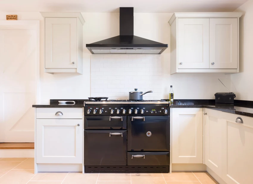White kitchen cabinets black oven hood countertop stove