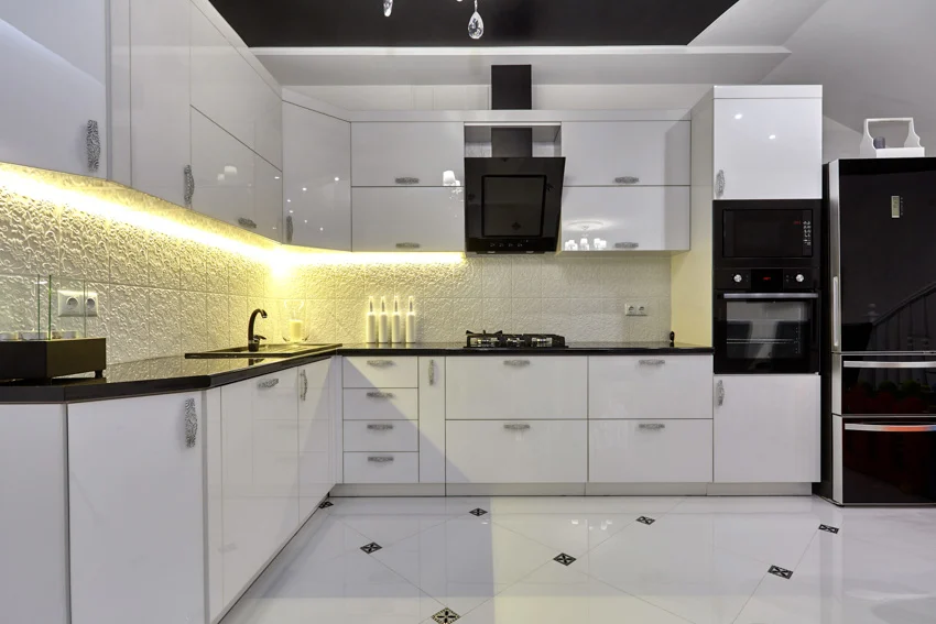 White kitchen cabinets tile flooring black oven hood countertop refrigerator