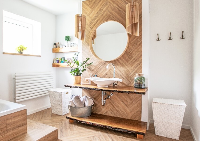 White sink on wood counter with a hanging round mirror bathroom interior