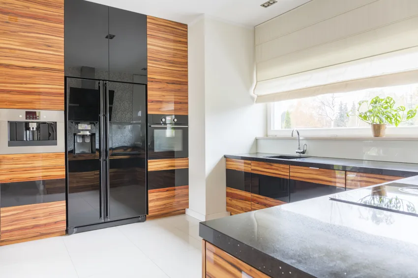 Wood cabinets black countertop refrigerator glass kitchen window