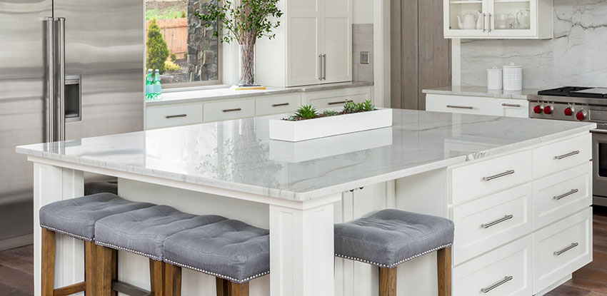 Kitchen island with quartz countertop stools stainless refrigerator white cabinets