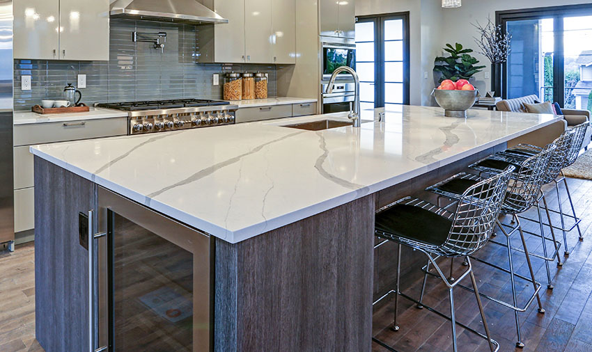 Kitchen with quartz island countertop steel chair green cabinets range-hood