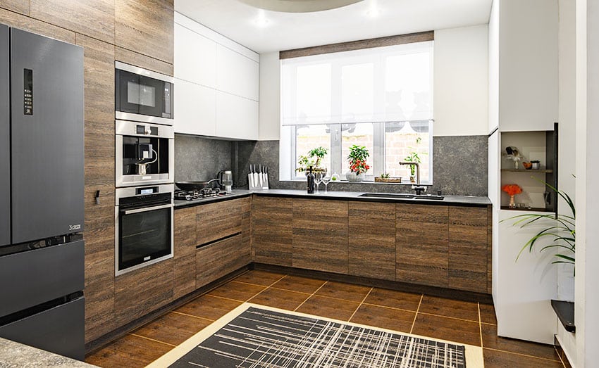 Kitchen with brown tiles, indoor plants, white walls and area rug