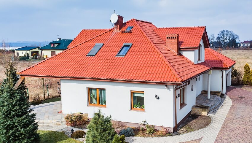 Aerial drone view on single family house with red roof garden and driveway