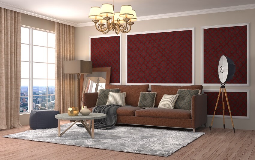 Apartment living room with chandelier lamp shades grey carpet brown sofa beige curtain and patterned maroon wall