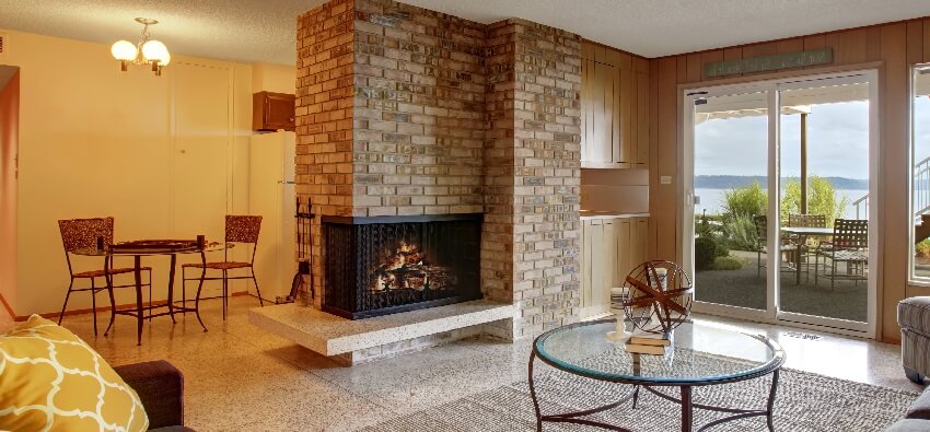 Basement living room with wooden wall trim brick fireplace and exit to walkout patio