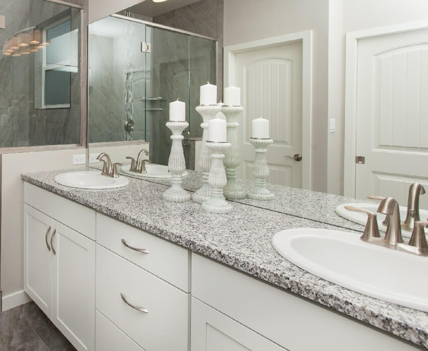 Bathroom with white drawers and a mirror