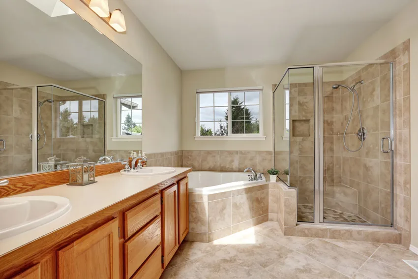 Vanity with his and hers wash basin, corner bathtub and shower enclosure