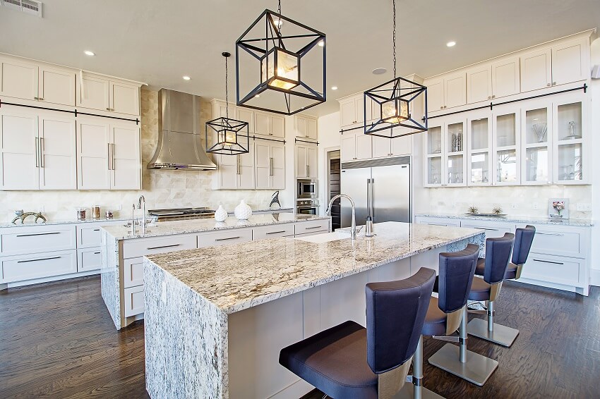 Beautiful kitchen with busy granite countertops ceiling lamps wooden floors and white cabinets