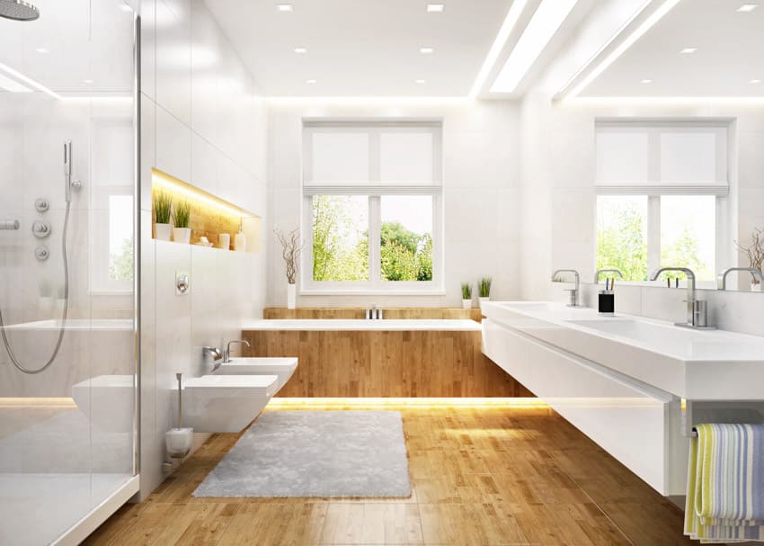 Beautiful bathroom wood floor glass shower cladded tub, oversize mirror countertop sink windows