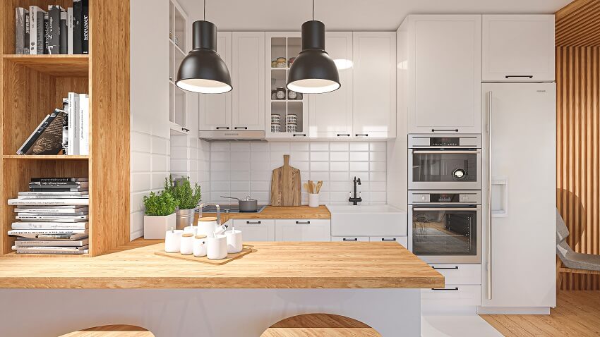 Beautiful white kitchen with kitchen appliances veneer countertops pendant lights and open shelves with books