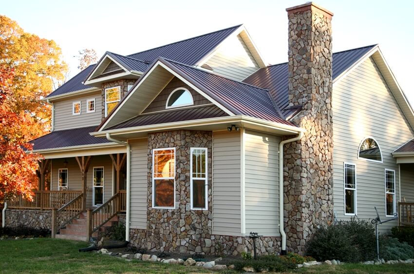 Beige stone house with bonnet overhang