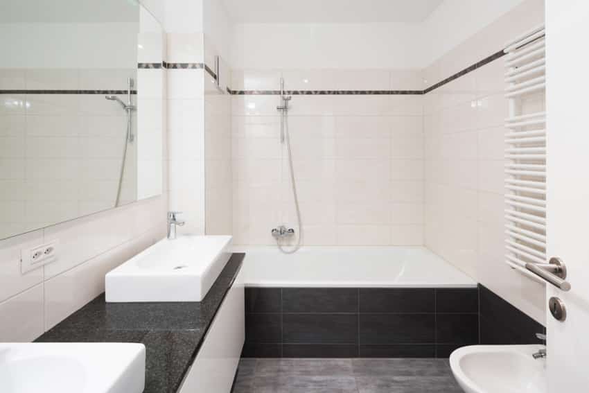 Black and white bathroom alcove tub tiles and mirror