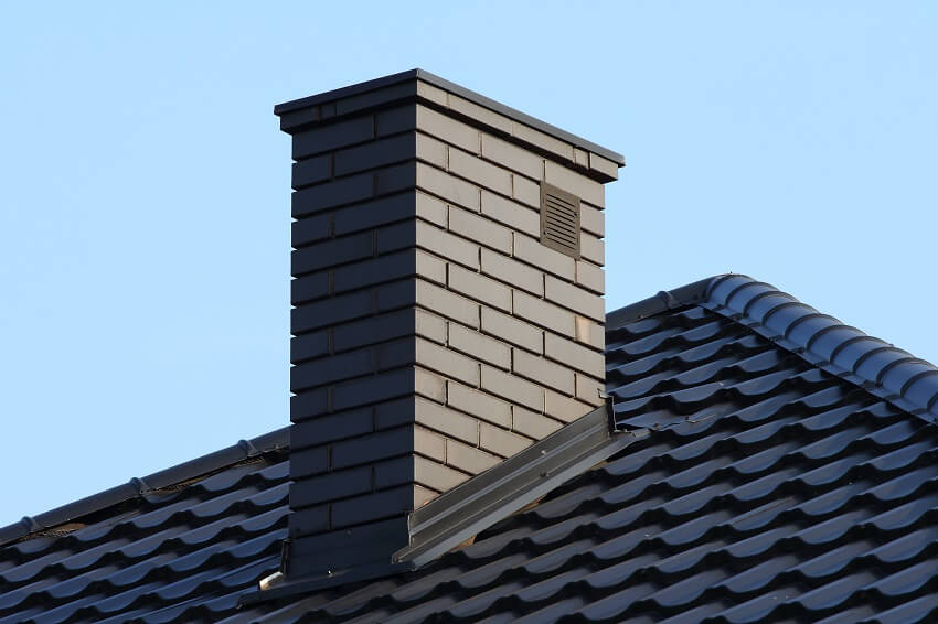 Black brick chimney on roof of a house