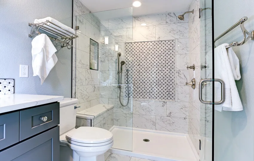 Blue bathroom design with surround marble shower glass doors cabinets toilet and racks with towels