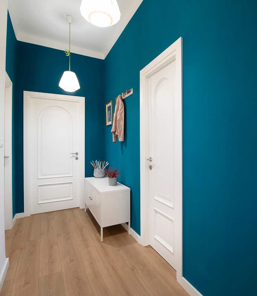 Blue painted hallway with parquet floor table and pendant lights